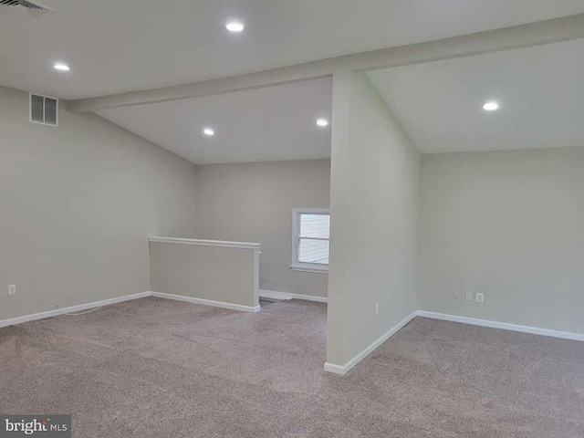 unfurnished room featuring vaulted ceiling with beams and light colored carpet