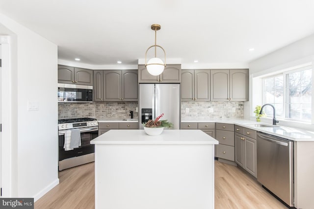 kitchen featuring sink, a center island, light hardwood / wood-style floors, and appliances with stainless steel finishes