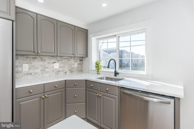 kitchen featuring dishwasher, backsplash, white refrigerator, sink, and gray cabinets