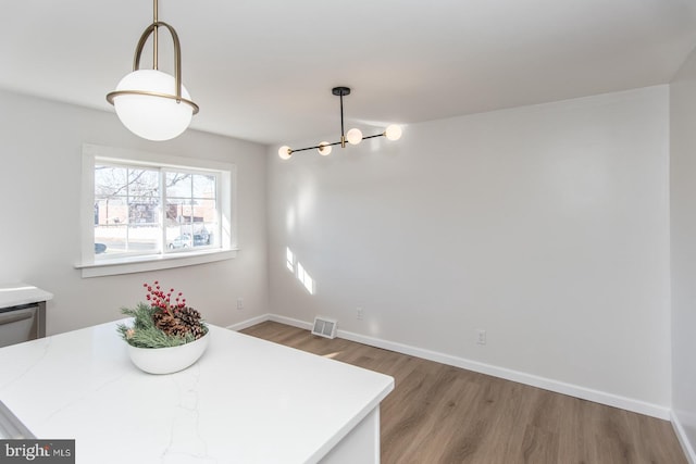 dining room featuring hardwood / wood-style floors and an inviting chandelier