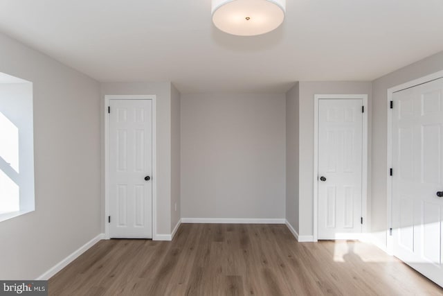 interior space with hardwood / wood-style flooring and multiple closets