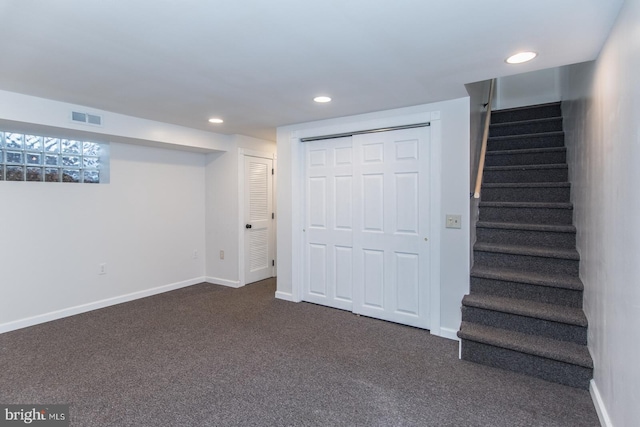 basement featuring dark colored carpet