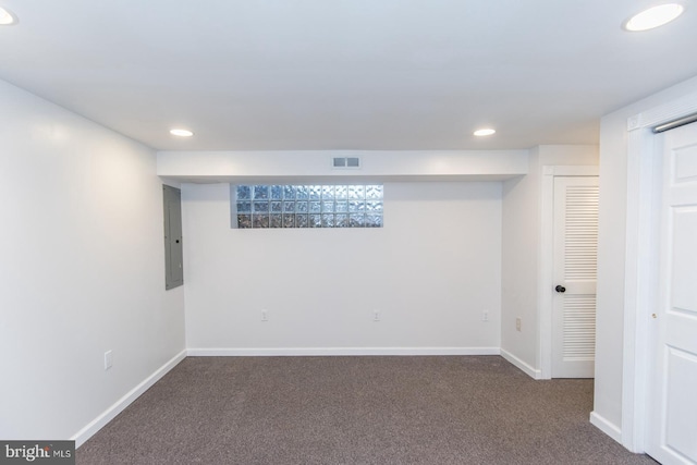 basement with dark colored carpet and electric panel