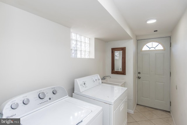 washroom featuring washer and dryer, light tile patterned floors, and sink