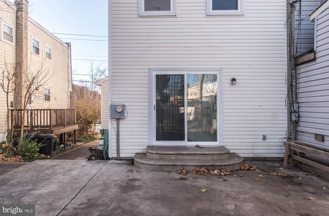 view of exterior entry with a patio