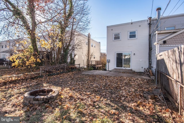 rear view of property with a patio area and an outdoor fire pit