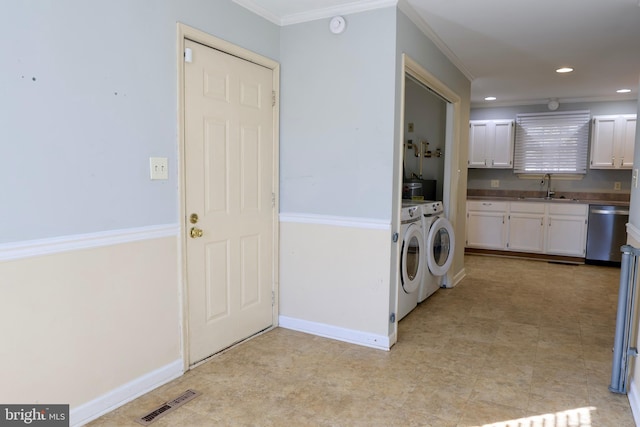 laundry area featuring sink, washer and clothes dryer, and ornamental molding