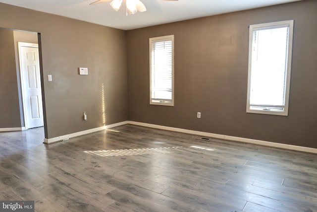 unfurnished room with ceiling fan, a healthy amount of sunlight, and dark hardwood / wood-style floors