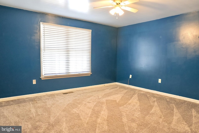 carpeted spare room with ceiling fan