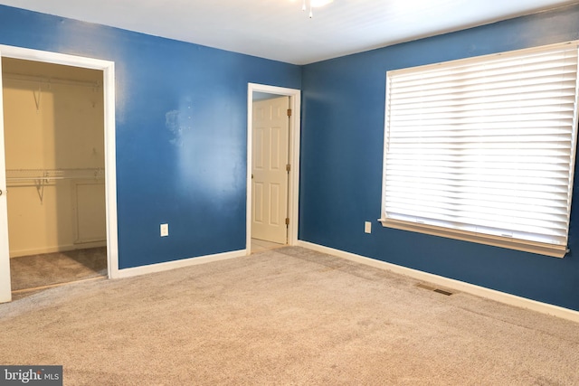 unfurnished bedroom featuring a closet and light carpet