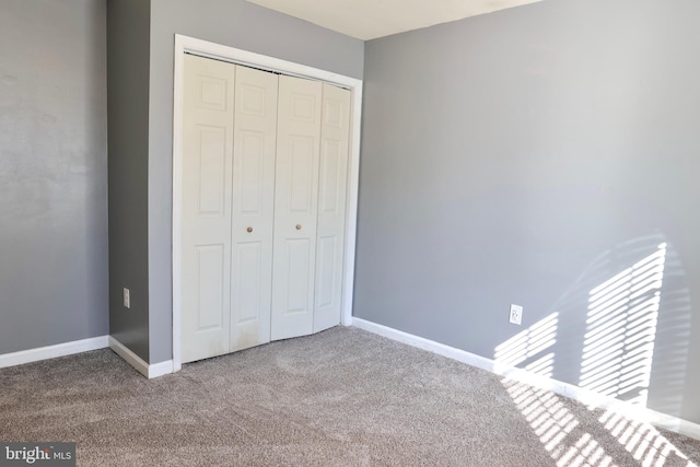 unfurnished bedroom featuring carpet floors and a closet