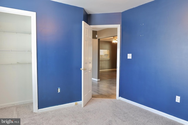 unfurnished bedroom featuring a closet and light carpet