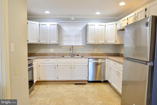 kitchen with sink, white cabinets, appliances with stainless steel finishes, and crown molding