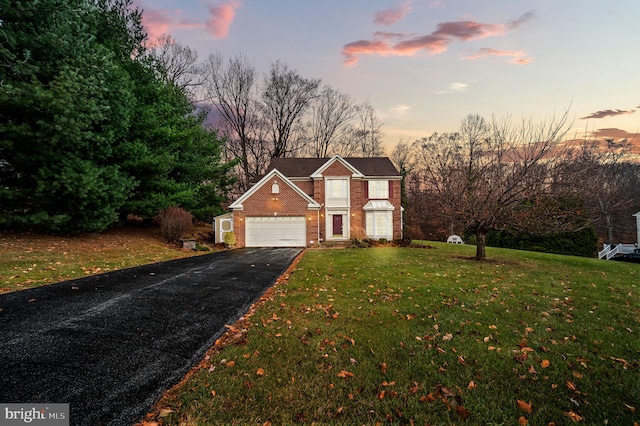 view of front of property featuring a yard and a garage