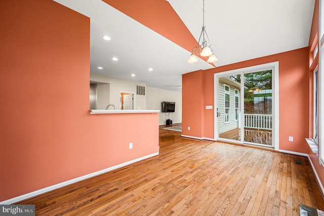 unfurnished dining area with light hardwood / wood-style flooring and a notable chandelier