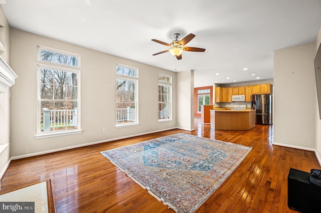 living room with hardwood / wood-style flooring, ceiling fan, and a wealth of natural light