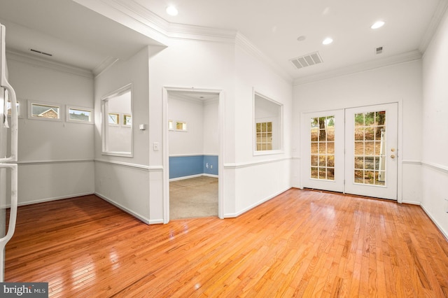 unfurnished room with light wood-type flooring and crown molding