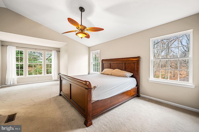 carpeted bedroom with ceiling fan, vaulted ceiling, and multiple windows