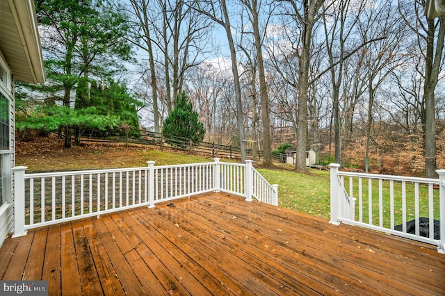 wooden deck with a lawn and a storage shed