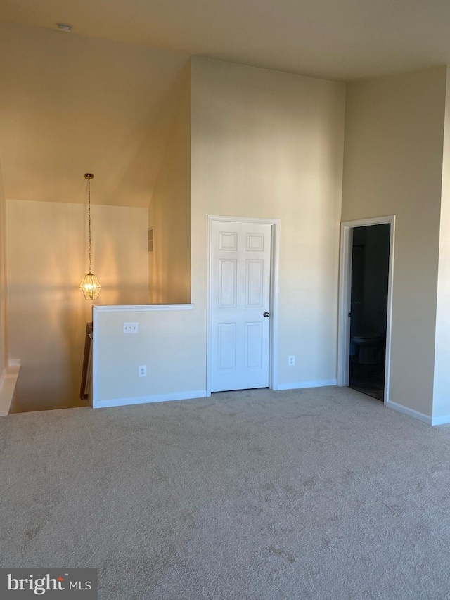 interior space featuring carpet flooring and high vaulted ceiling