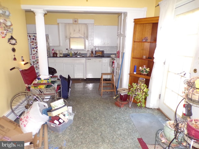 kitchen featuring decorative columns, sink, white cabinets, and white appliances