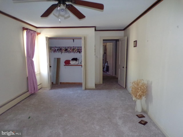 unfurnished bedroom with ceiling fan, baseboard heating, crown molding, light carpet, and a closet