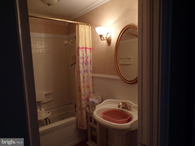 bathroom featuring shower / bath combo, ornamental molding, and sink