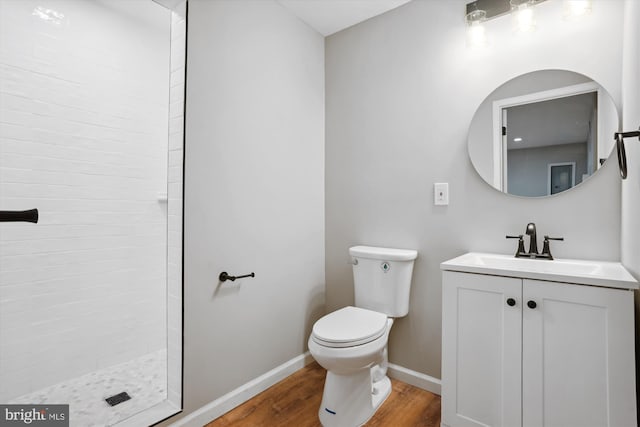 bathroom with a shower, vanity, hardwood / wood-style flooring, and toilet