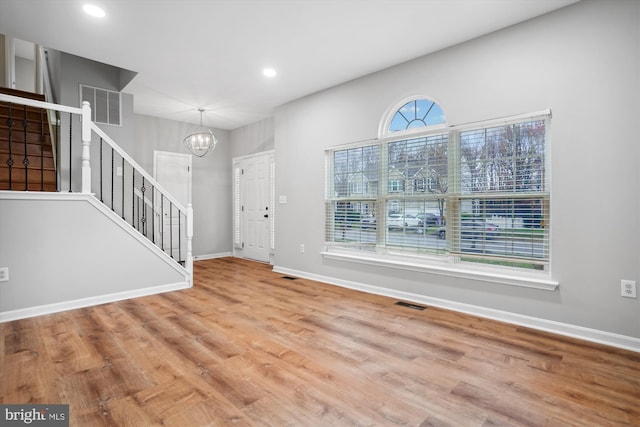 entrance foyer with wood-type flooring and an inviting chandelier