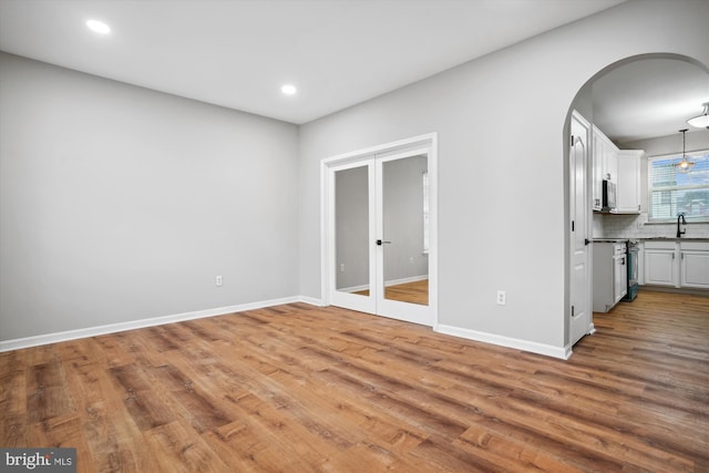 interior space with wood-type flooring, french doors, and sink