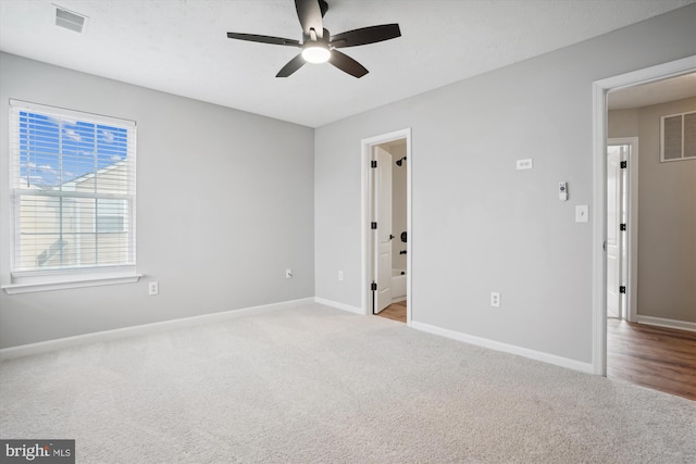 carpeted spare room featuring ceiling fan