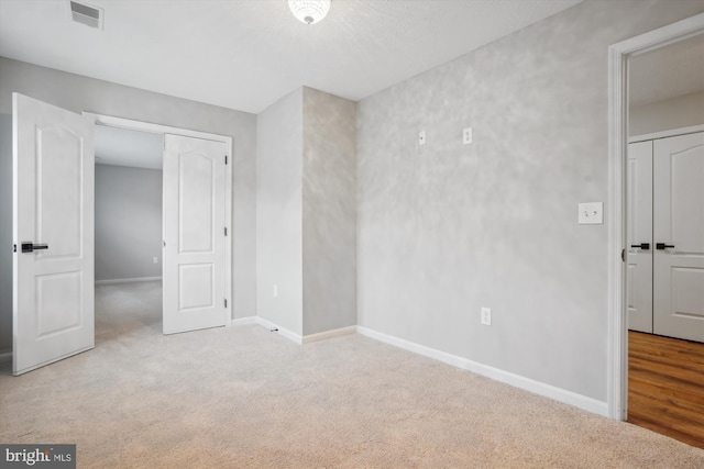 unfurnished room featuring light carpet