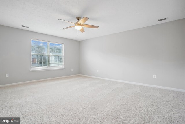 carpeted spare room featuring ceiling fan