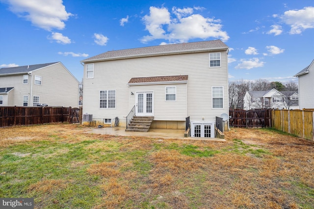 back of property with french doors, a yard, and a patio