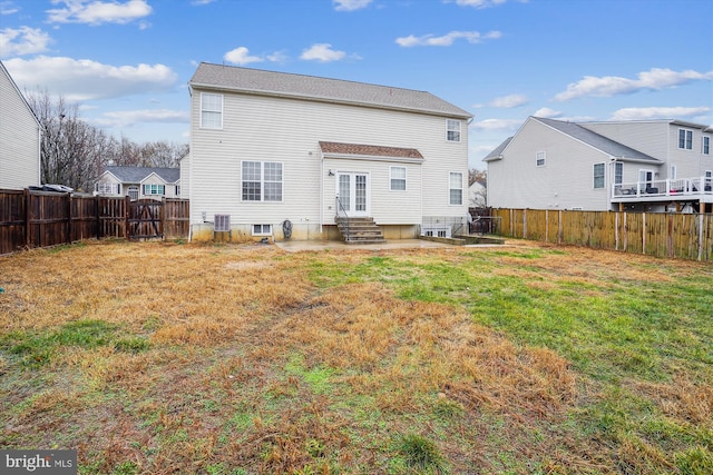 rear view of house with a lawn and central AC