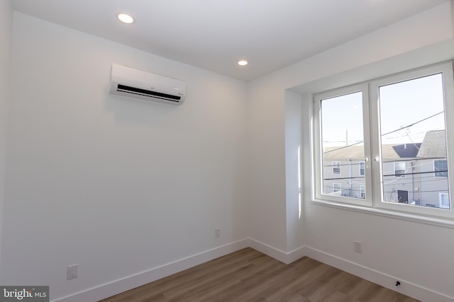 empty room with a wall unit AC and hardwood / wood-style floors