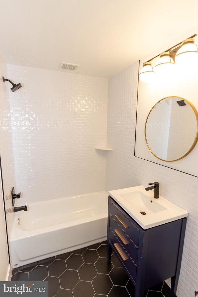 bathroom featuring tile patterned floors, vanity, tile walls, and washtub / shower combination