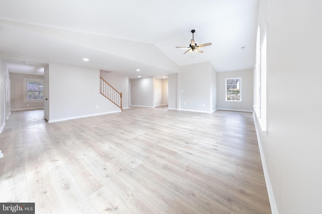 unfurnished living room with ceiling fan, lofted ceiling, and light wood-type flooring