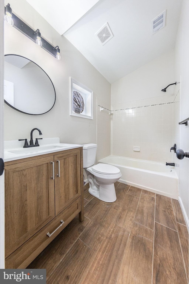 full bathroom with vanity, tiled shower / bath, and toilet