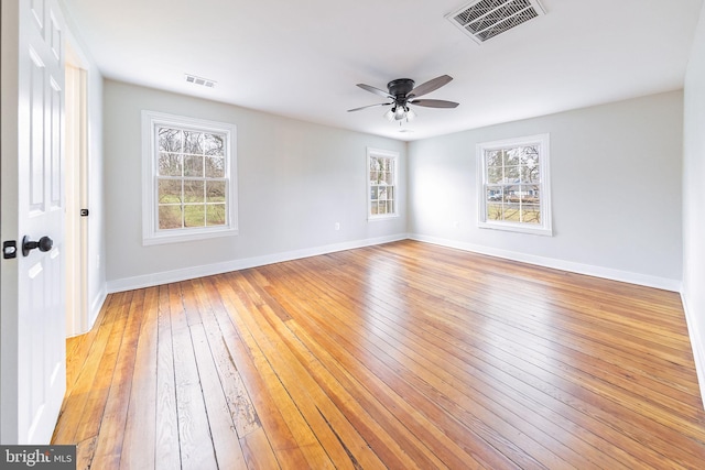 spare room featuring a wealth of natural light, light hardwood / wood-style flooring, and ceiling fan