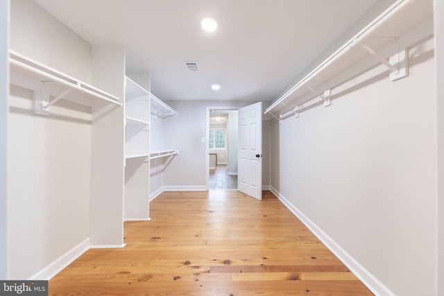 spacious closet with hardwood / wood-style flooring