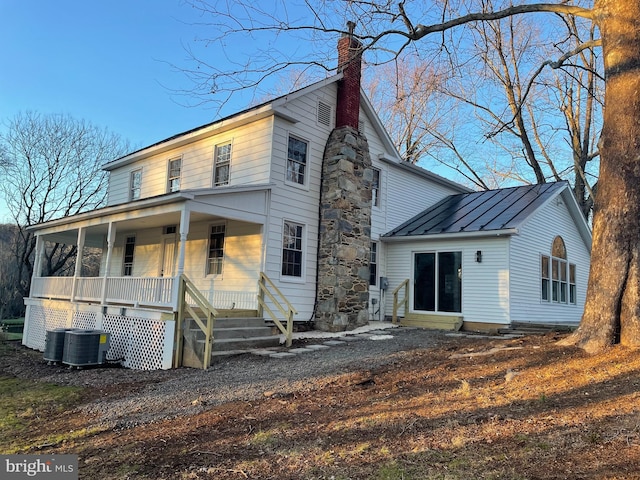 rear view of property with central AC unit and a porch