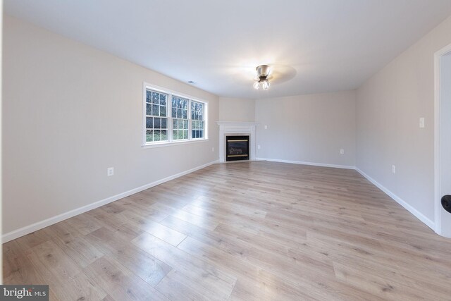 unfurnished living room featuring ceiling fan and light hardwood / wood-style flooring