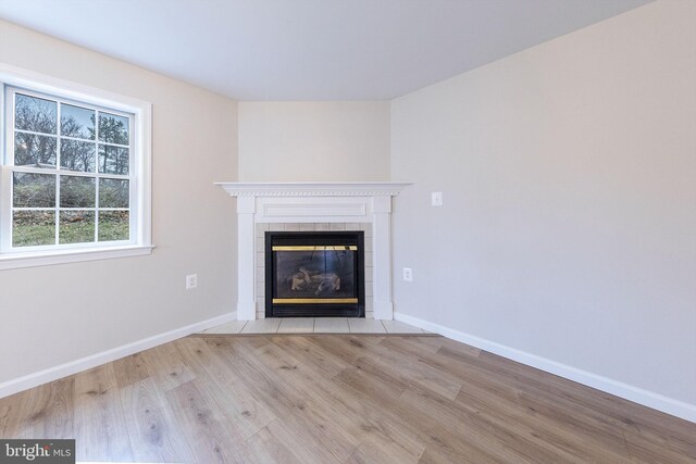 interior details with a tile fireplace and hardwood / wood-style flooring