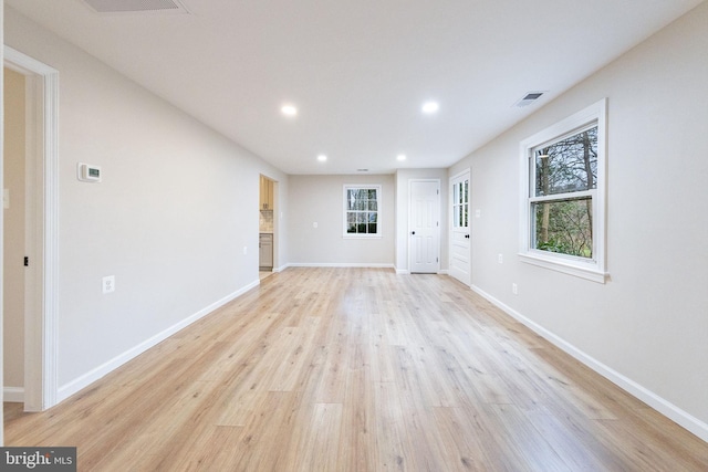 unfurnished living room featuring light wood-type flooring and a healthy amount of sunlight