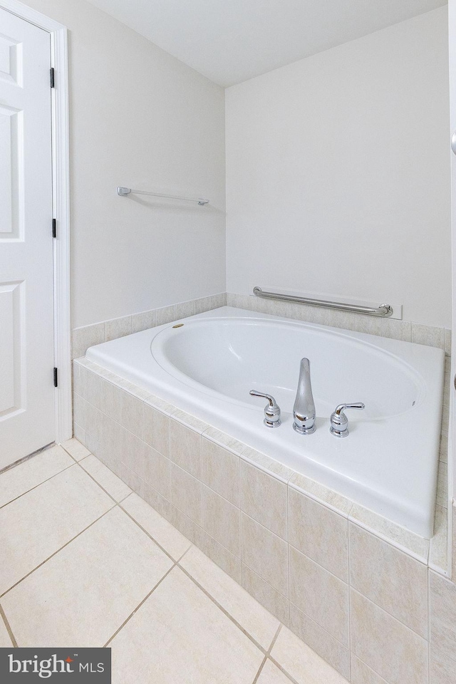 bathroom with tiled bath and tile patterned flooring