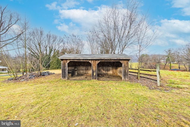 view of outdoor structure featuring a lawn and a rural view