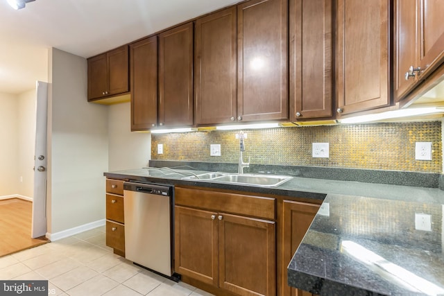 kitchen with light tile patterned floors, backsplash, stainless steel dishwasher, and sink