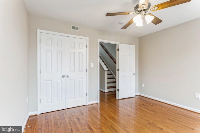 unfurnished bedroom featuring ceiling fan, light hardwood / wood-style floors, and a closet