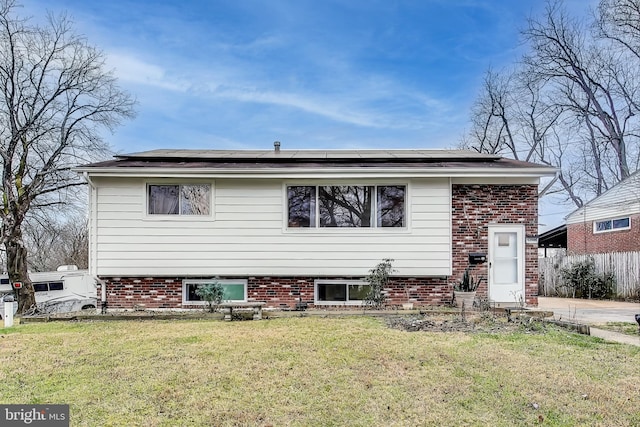 view of front of home with a front yard and solar panels